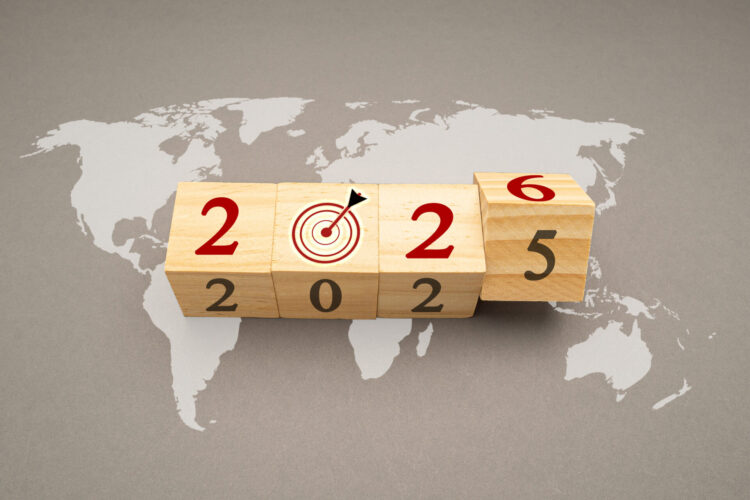 Happy new year 2026. Flipping of 2025 to 2026 on wooden cubes over the world map background for preparation of new year change and starting new business target strategy concept
